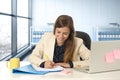 Woman on her 30s at office working at laptop computer desk taking notes Royalty Free Stock Photo