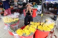 A woman at her stall selling flowers in one of the streets in the Ba Le market in Hoi An Royalty Free Stock Photo