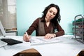 Woman at her working desk with blueprints in front Royalty Free Stock Photo