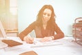 Woman at her working desk with blueprints in front Royalty Free Stock Photo