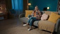 A woman and her young daughter are watching TV using a remote control. Mom and daughter sitting in an embrace in the Royalty Free Stock Photo