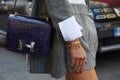 Woman with Hermes crocodile blue leather bag and golden Cartier bracelets before Ermanno