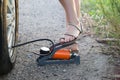 The woman herself pumps up the cars tire with a foot mechanical pump Royalty Free Stock Photo