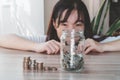 The woman hid behind a jar full of coins, saving for future and financial concept. Royalty Free Stock Photo