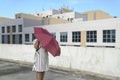 Woman hidden behind a red umbrella. Urban creative concept