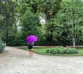 Woman hidden by purple umbrella strolls Luxembourg Garden, Paris, France Royalty Free Stock Photo
