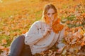 Woman hide her face with yellow autumnal leaf. Happy beautiful girl have a good time resting in a autumnal golden park Royalty Free Stock Photo