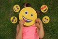 A woman hides her face behind emojis making faces Royalty Free Stock Photo