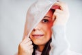 The woman hides her face behind the hood. Stylish female posing in a hoodie. Portrait of a young woman covering her face
