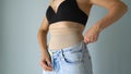 Woman hides the imperfection of the figure under the pulling corrective underwear. Wearing jeans on top, jeans fit