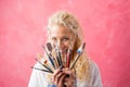 Woman hiding behind paint brushes Royalty Free Stock Photo