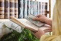 Woman hiding dollar banknotes in book, closeup. Money savings