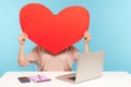 Woman hiding face behind huge red paper heart, symbol of love, romantic feelings, using anonymous dating service