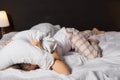 Woman hiding under pillow in bed