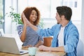 Woman, high five and man with laptop in office for achievement, success and teamwork. Diverse employees, touching hands Royalty Free Stock Photo