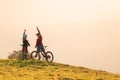 Woman high five over the sunset at mountain biking trip Royalty Free Stock Photo