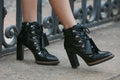 Woman with high heel black leather boots before fashion Tod`s show, Milan Fashion Week street style on