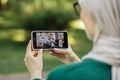Woman in hijab having video call with her friends, blond woman and man using wheelchair Royalty Free Stock Photo