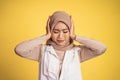 Woman in hijab holding head while confused by situation Royalty Free Stock Photo