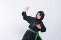 Woman in hijab in pencak silat uniform poses stance and fend off attacks with copyspace