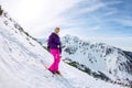 Woman hikeing in the snowy mountains with a phone and snowshoes. and backpack