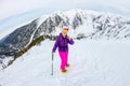 Woman hikeing in the snowy mountains with a phone and snowshoes. and backpack Royalty Free Stock Photo