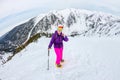 Woman hikeing in the snowy mountains with a phone and snowshoes. and backpack