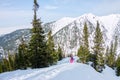 Woman hikeing in the snowy mountains with a phone and snowshoes. and backpack Royalty Free Stock Photo