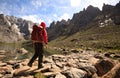 Hiker with backpack walking on high altitude mountains Royalty Free Stock Photo