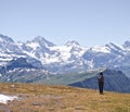 Woman hiker with backpack hiking on plateau with high altitude mountains in the background. Royalty Free Stock Photo