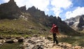 Hiker with backpack walking on high altitude mountains Royalty Free Stock Photo