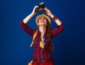 Woman hiker on blue background with DSLR camera taking photo Royalty Free Stock Photo