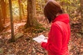 Woman hiker checking a map on a forest path in autumn Royalty Free Stock Photo