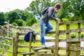 Woman Hiker Climbing over a Fence on a Sunny Spring Day Royalty Free Stock Photo