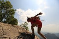 Woman hiker climbing rock on mountain peak cliff Royalty Free Stock Photo