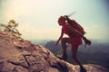 woman hiker climbing rock on mountain peak cliff Royalty Free Stock Photo