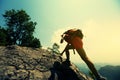 Woman hiker climbing rock on mountain peak cliff Royalty Free Stock Photo