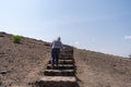 Woman hiker climbs the steep staircase to Observation Hill in Amboseli National Park Kenya Africa Royalty Free Stock Photo