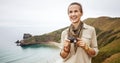 Woman hiker with digital camera looking into distance