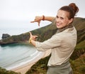 Woman hiker framing with hands in front of ocean view landscape
