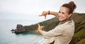 Woman hiker framing with hands in front of ocean view landscape