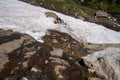 Woman hiker gets stuck on a cliff in a snowfield. Concept for dangerous hiking, hiking solo