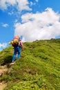 Woman hiker goes uphill Royalty Free Stock Photo