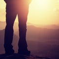 Woman hiker legs in tourist boots stand on mountain rocky peak. Sunny day Royalty Free Stock Photo