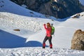 Woman hiker looking back towards a recent wet snow avalanche, in Malaiesti Valley, Bucegi mountains, Romania