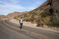 Happy woman hiker with her arms open in the middle of the road in Argentina Royalty Free Stock Photo