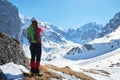 Woman hiker pointing towards Malaiesti Valley and Hornul Mare chimney, in Bucegi mountains, Romania, on a sunny Winter day. Royalty Free Stock Photo