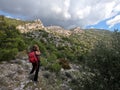 Woman hiker with red backpack photographing mountain scenery in Greece