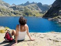 A woman hiker rests near a mountain lake Royalty Free Stock Photo