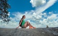 Woman hiker seated alone on rocky mountain cliff enjoying view of nature on wilderness trail. Active way of life concept Royalty Free Stock Photo